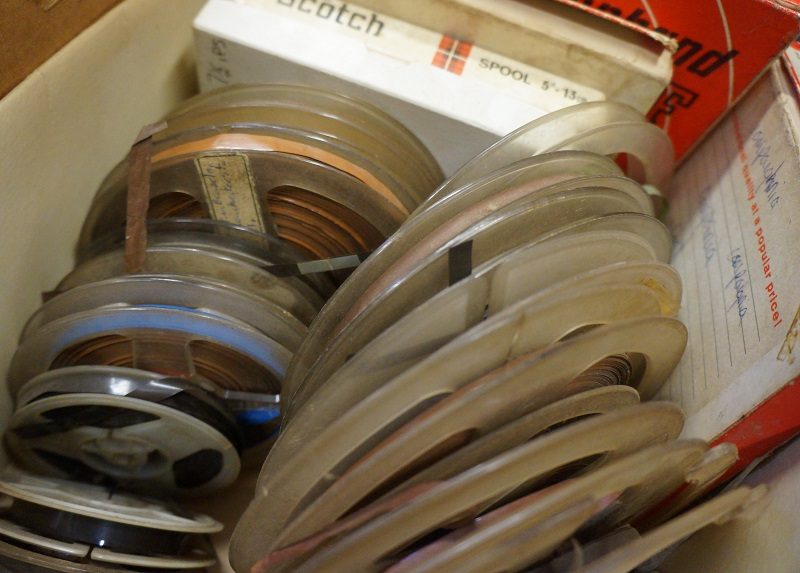 A box of full of reel to reel tapes, the spools are dirty because of how they were stored