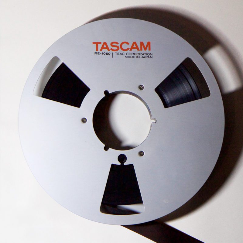 Aluminium Tascam spool containing 1 inch dark brown tape