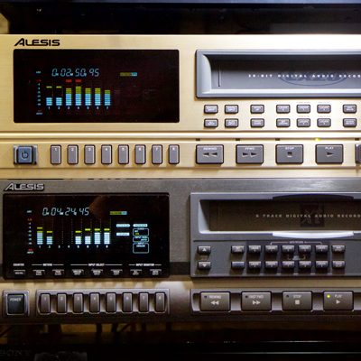 2 rack-based Alesis machines with multiple buttons and bar-level display, upper one is gold-coloured and lower one is brushed steel