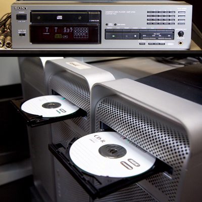 Top: professional compact disc player, labelled 'Custom File'. Bottom: 3 large silver-coloured computers with CD-Rs loaded in their open disc drive trays