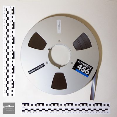 Aluminium Ampex spool with half inch brown magnetic tape and rulers indicating dimensions