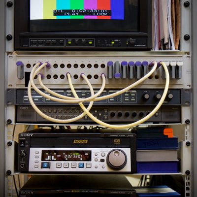 enlarged image shows JVC Hi Resolution monitor with colour bars, patch bay with cables and Sony HDCAM recorder