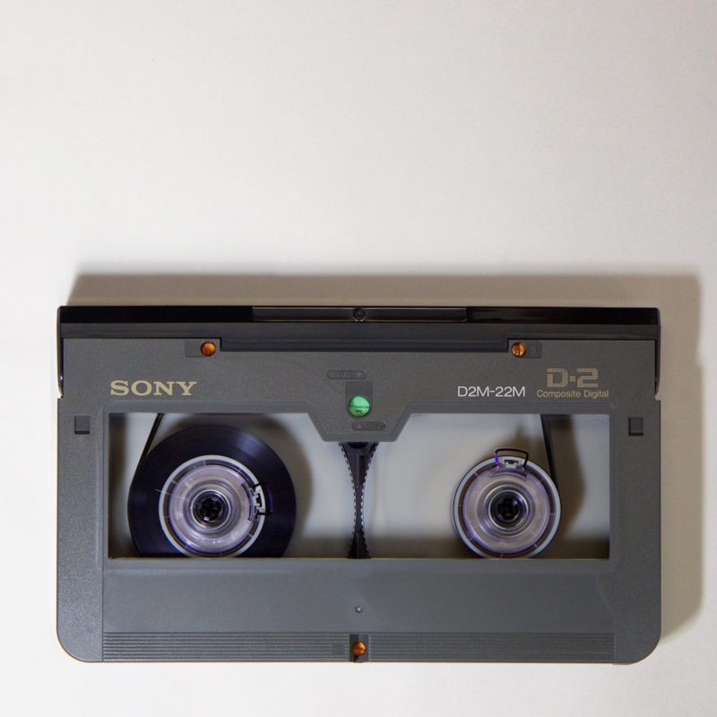 grey rectangular D-2 videocassette with bottom corners rounded