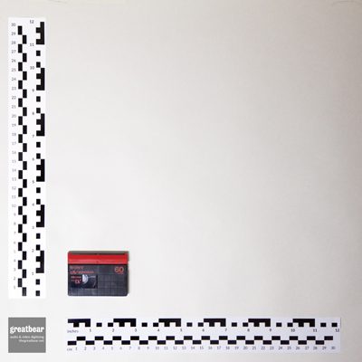 black and red rectangular plastic miniDV cassette with rulers indicating width 6.5cm and height 4.8cm