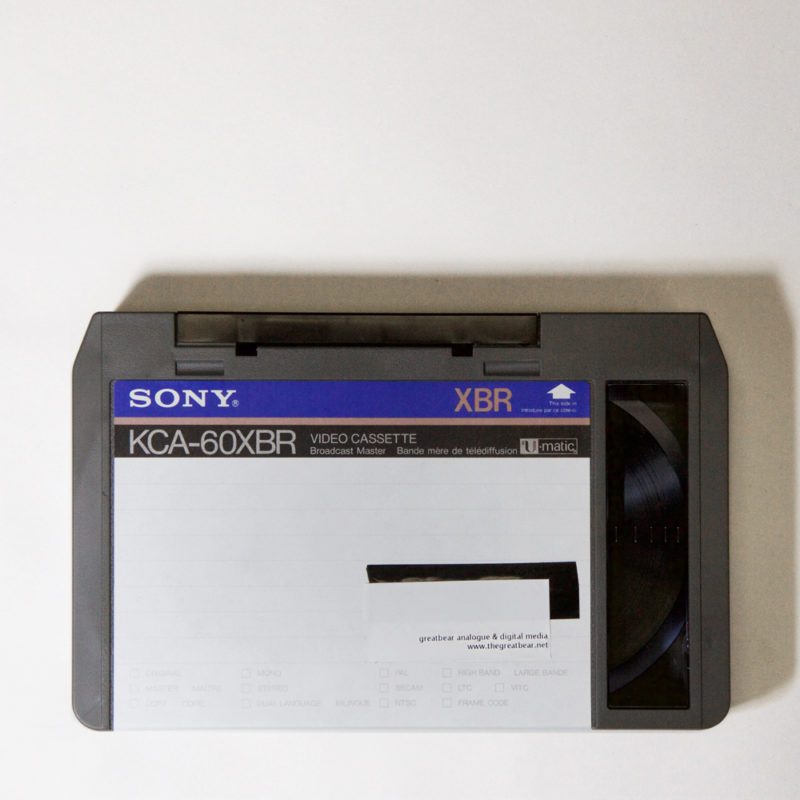 dark grey plastic cassette, rectangular with bevelled upper corners