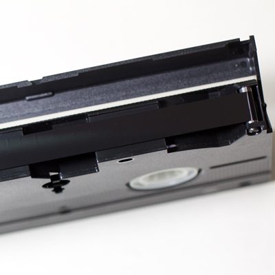 tape end view of cassette with protective shell opened to reveal 12.7 mm (½ inch) black magnetic tape
