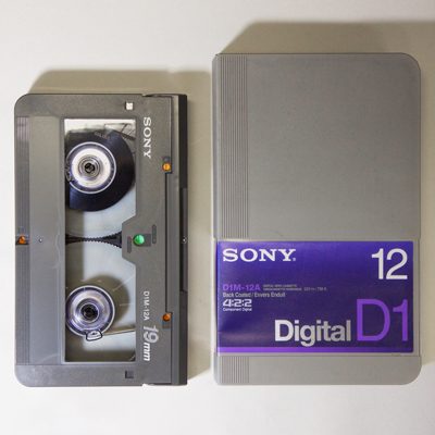 Large D-1 video cassette alongside grey plastic box labelled Sony 12 Digital D-1
