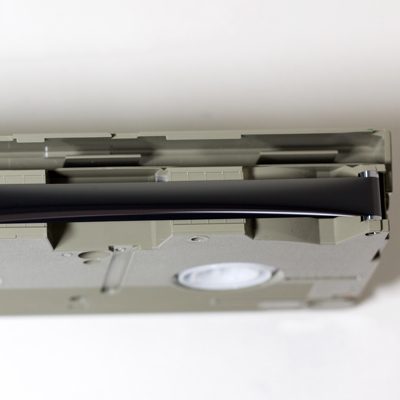 end view of MII (M2) video cassette with protect shield opened revealing shiny black magnetic tape