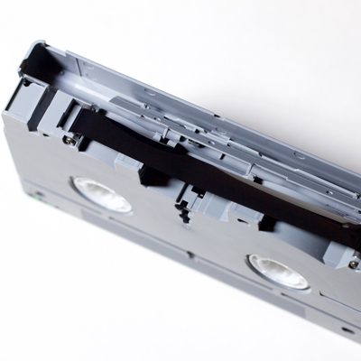 end view of Digital S video cassette with protective shield open to reveal black magnetic tape