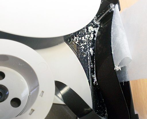 black plastic tape shedding a white powdery substance being wiped gently with white cleaning cloth