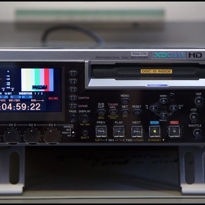 Black and silver-coloured XDCAM machine with colour bars on LCD display